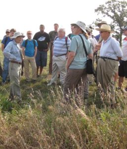 a group of people standing in a prairie landscape